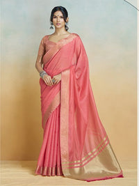 Woman wearing a pink saree with a gold border against a gradient background